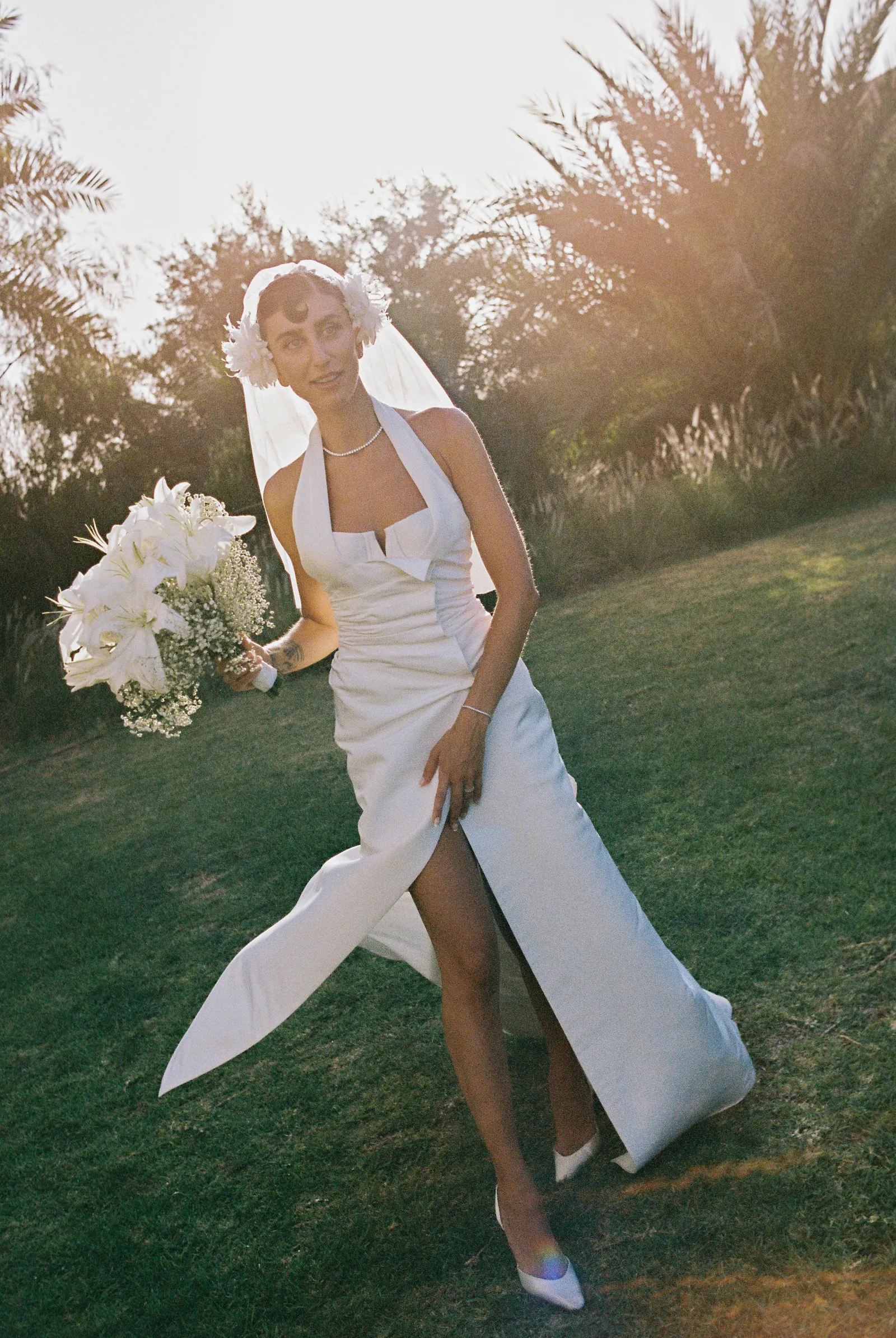 Image may contain Clothing Dress Fashion Formal Wear Gown Wedding Wedding Gown Flower and Flower Arrangement