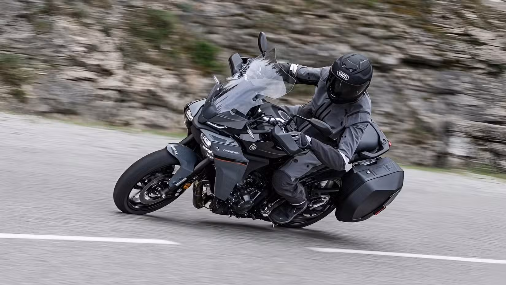 Action shot of a rider cornering the 2026 Tracer 9 on a mountain pass