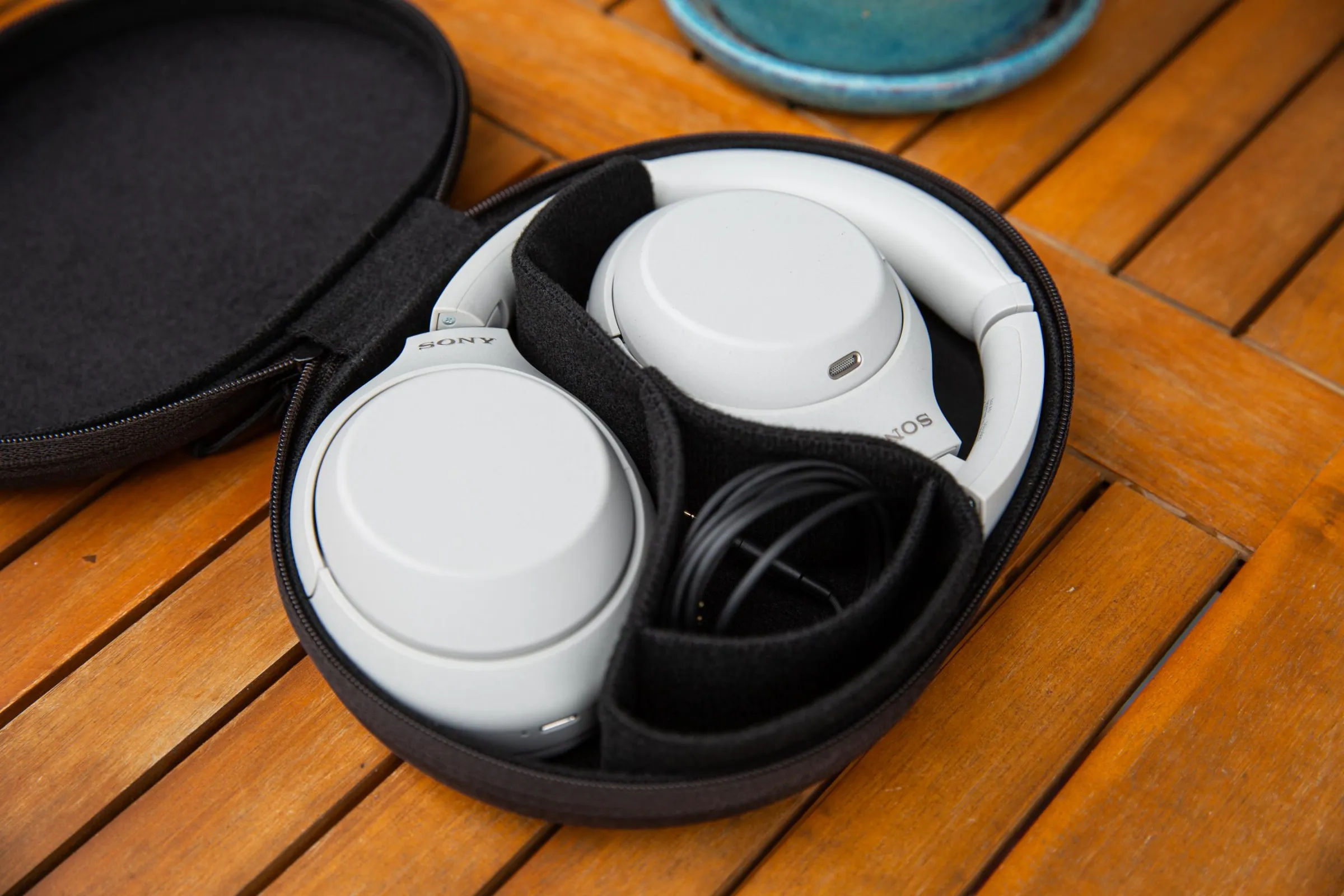 The Sony XM4C in their carrying case on a wooden table.
