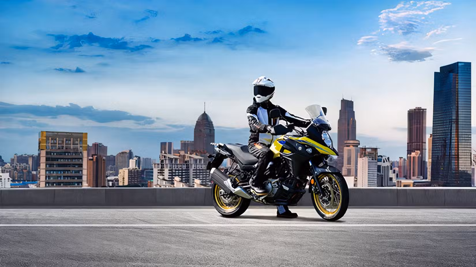 Static shot of a rider on a Suzuki V-Strom 650XT in front of a city skyline