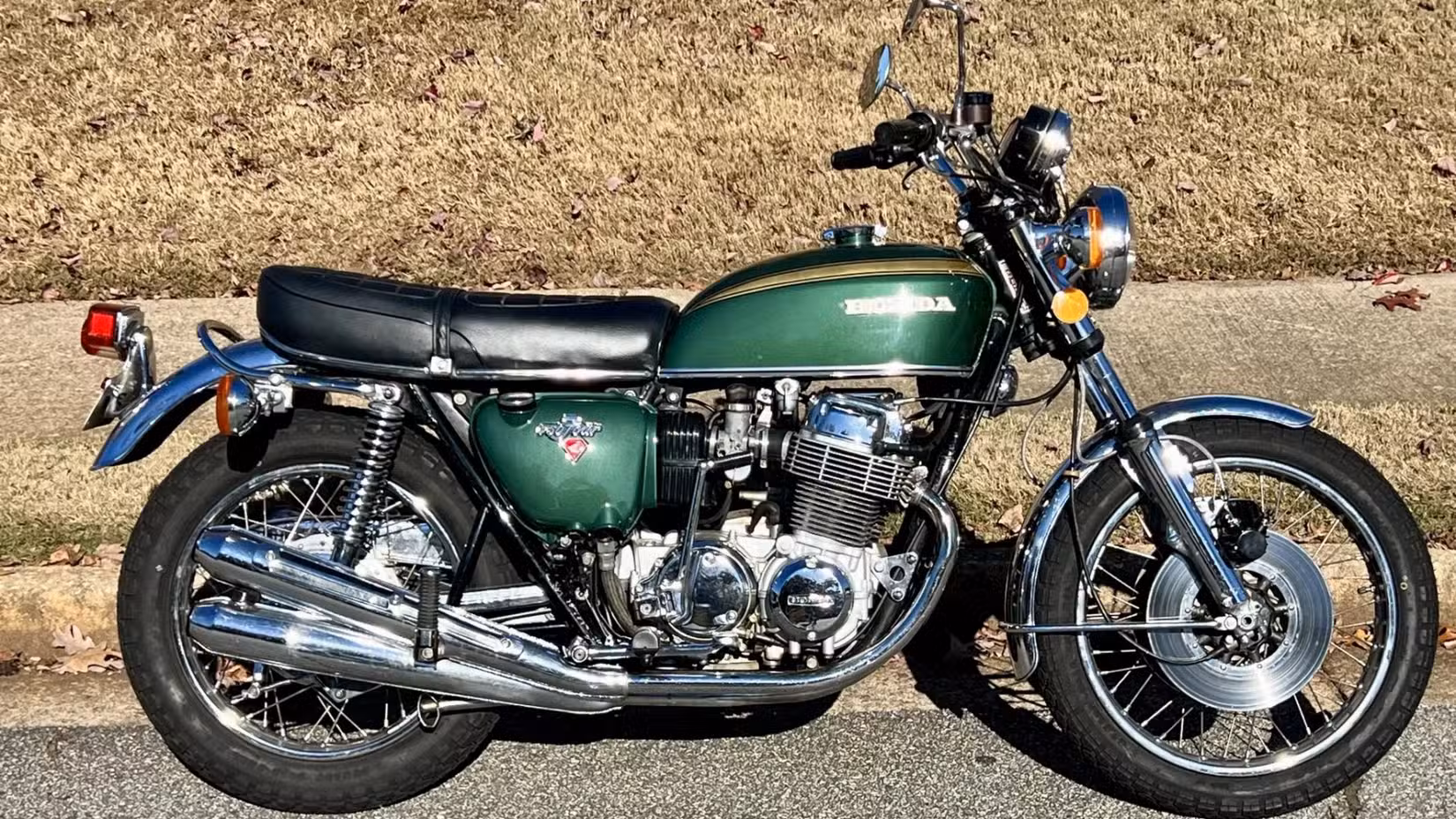 Static shot of a green 1972 Honda CB750 parked on the side of the road