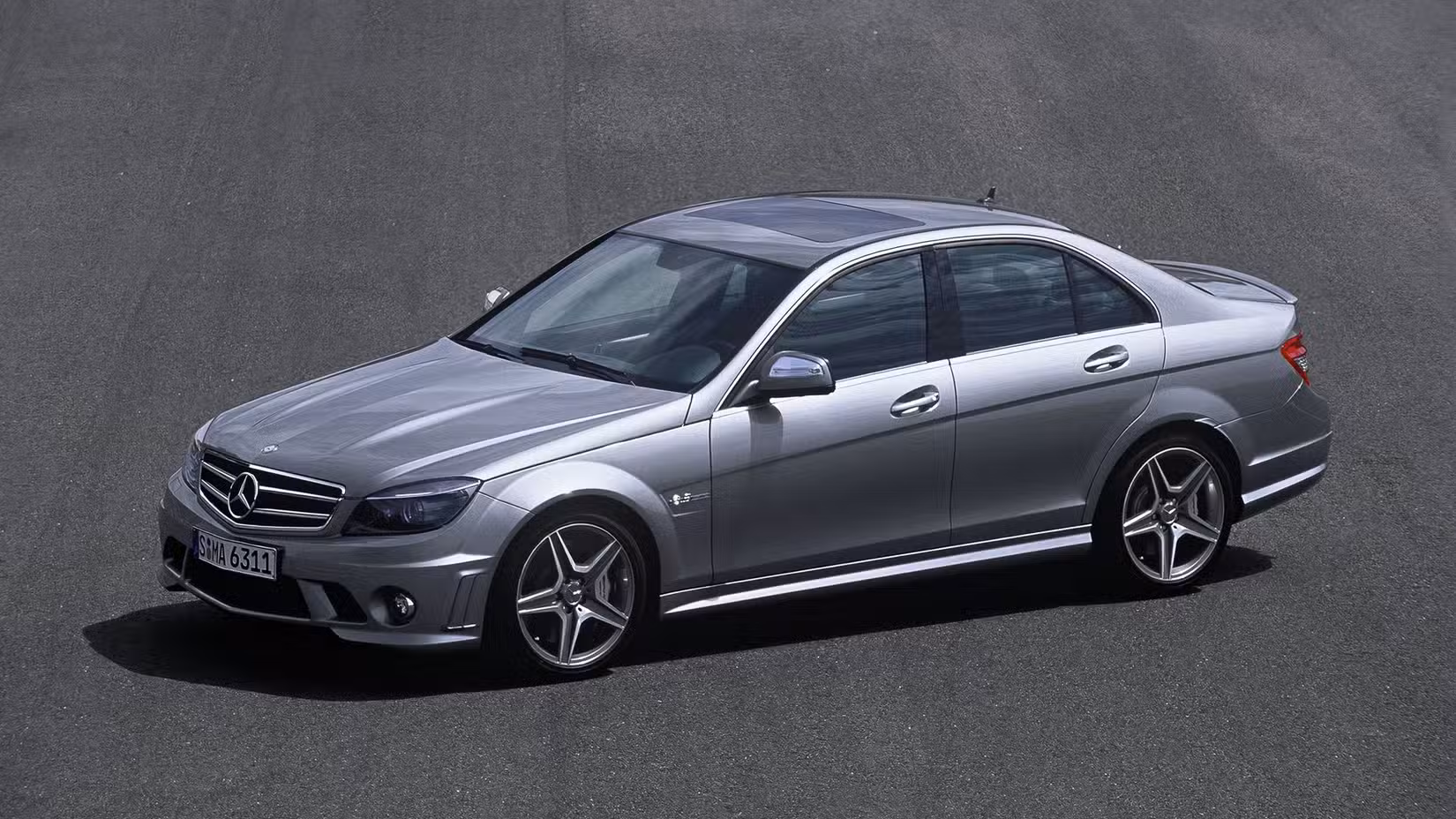 Front 3/4 shot of a silver 2008 Mercedes-AMG C63 Sedan in parking lot