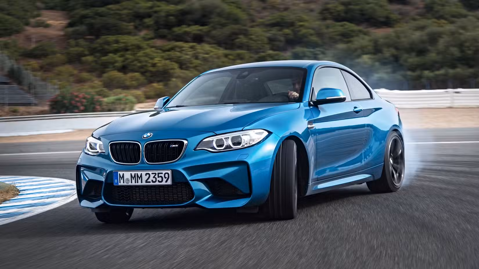 Front action shot of 2016 BMW M2 in blue being driven on track