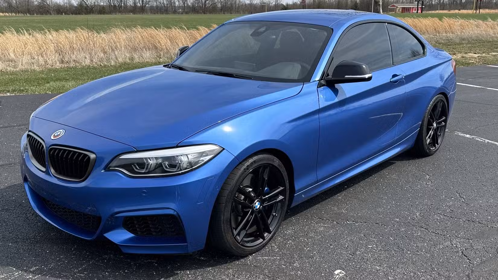 The front 3/4 view of a blue 2021 BMW M240i Coupe.