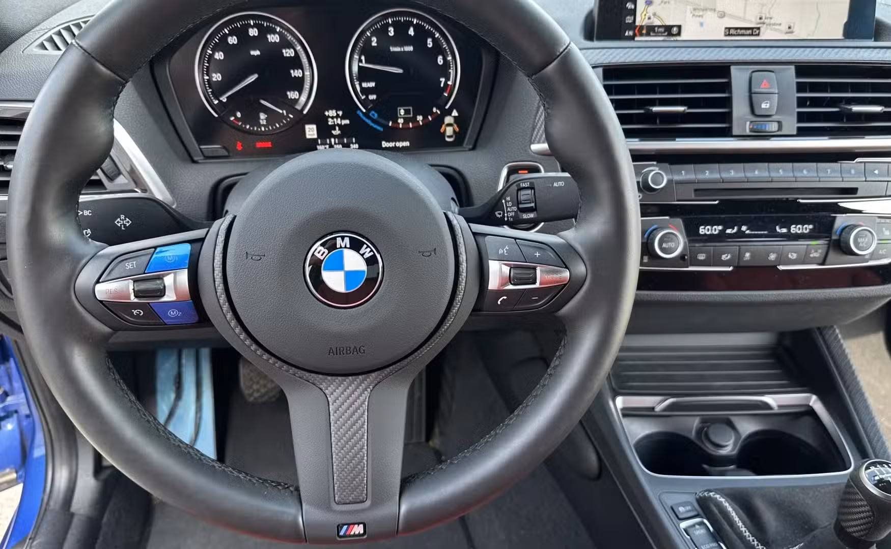 The steering wheel view of a blue 2021 BMW M240i Coupe.