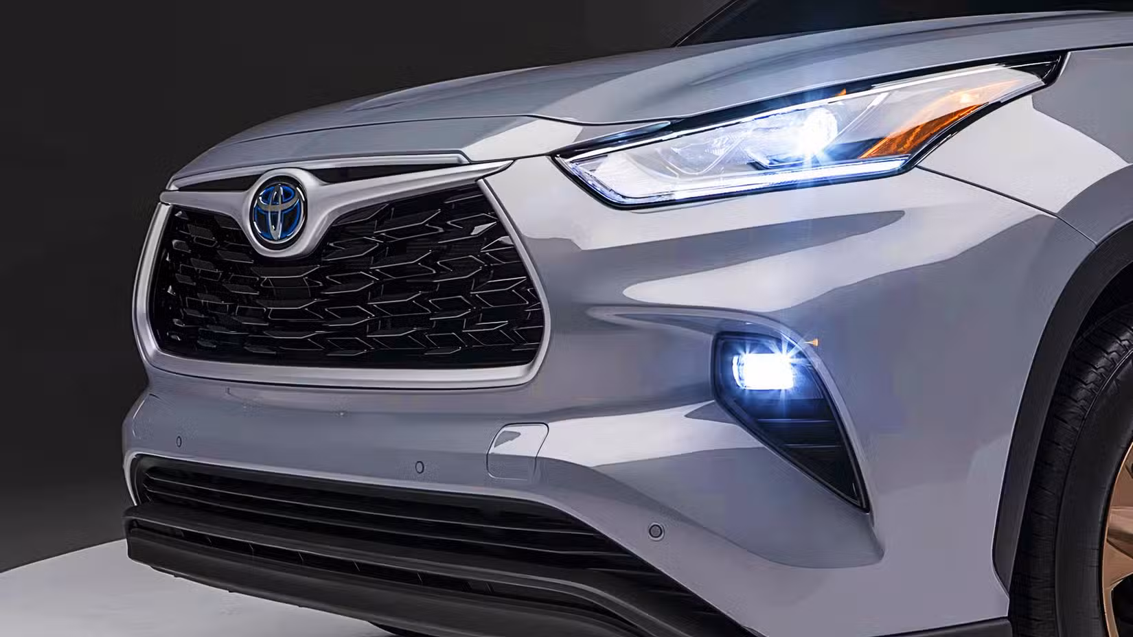 The front of a gray 2022 Toyota Highlander Hybrid midsize hybrid SUV. 