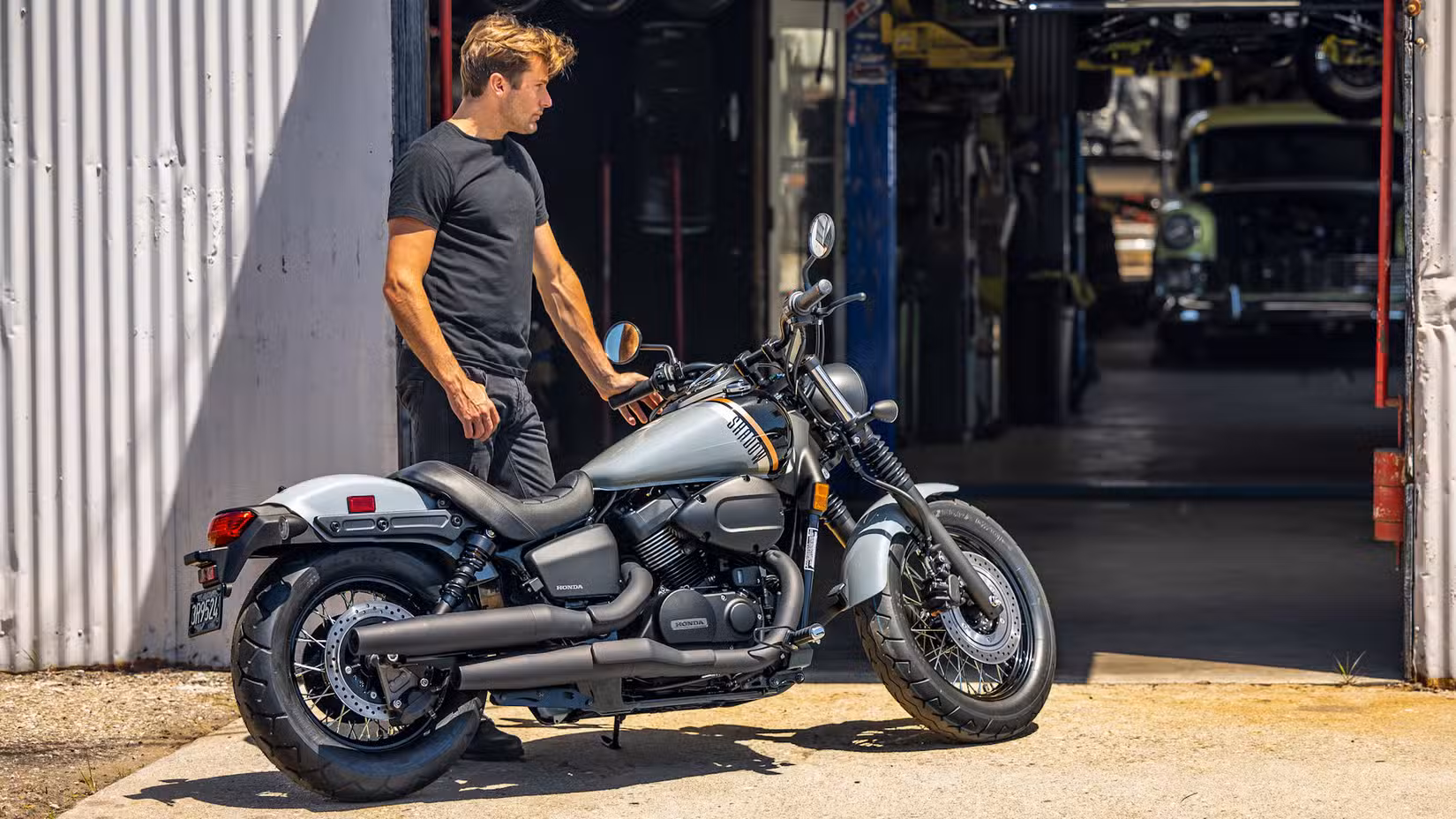 Static outdoor shot of a guy admiring a Honda Shadow Phantom
