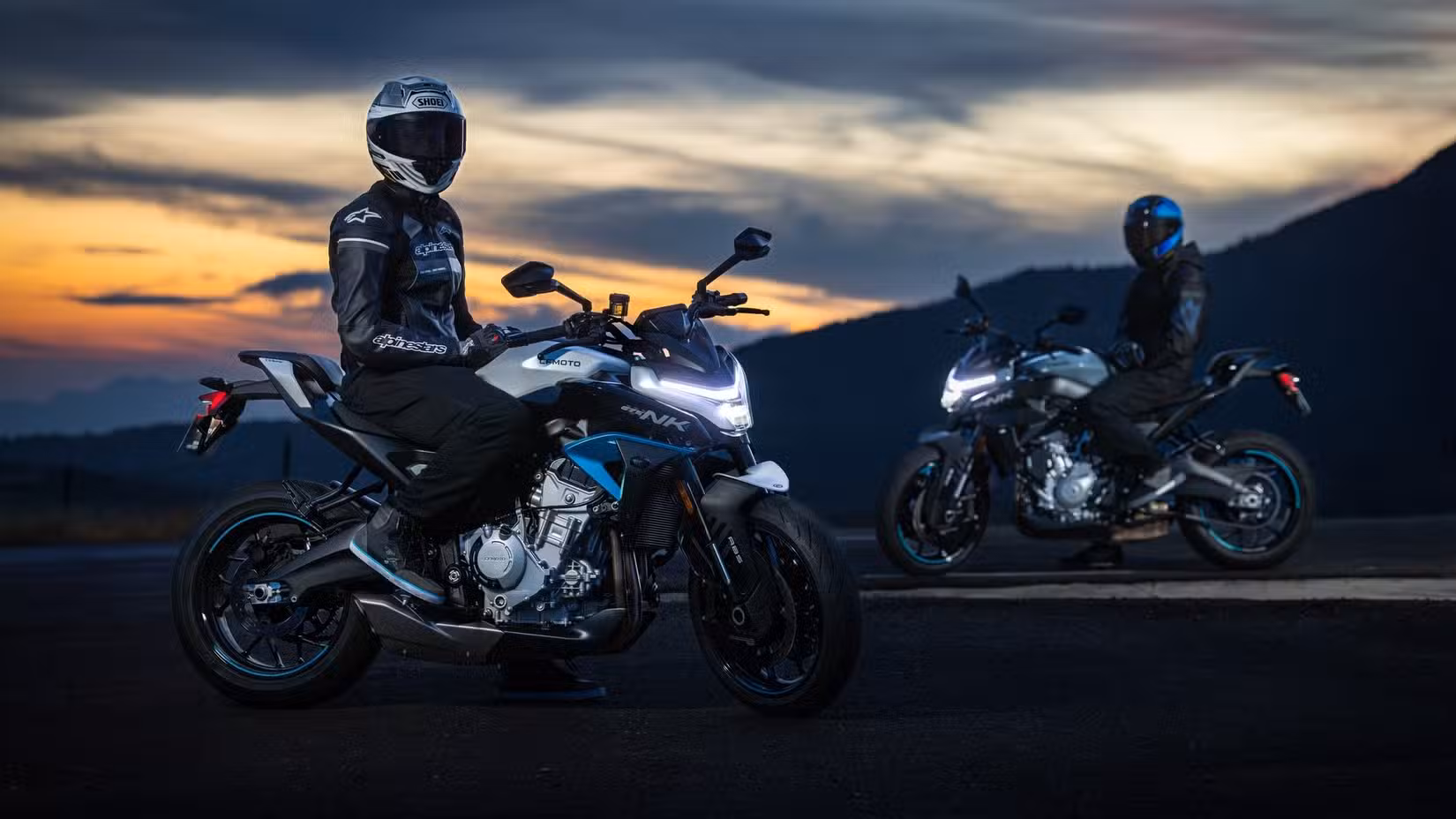 A couple of riders sitting on 2025 CFMoto 675NKs at dusk