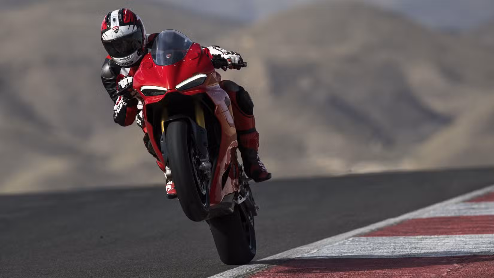 2025 Ducati Panigale V2 performing a power wheelie on a racetrack