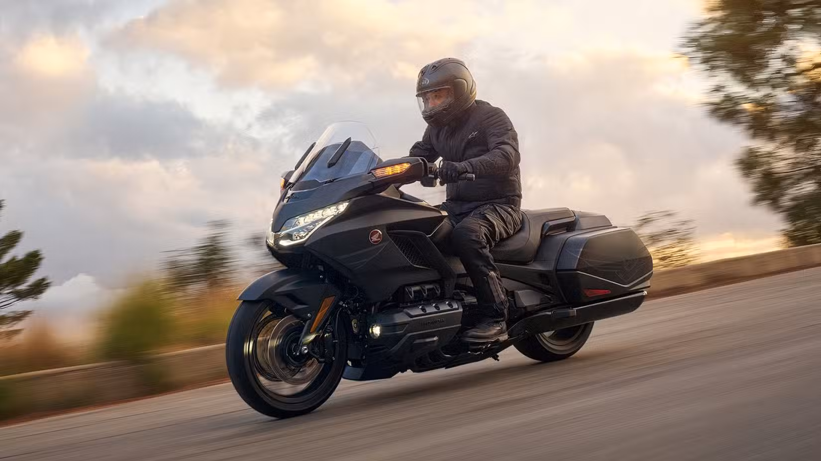 Side shot of a 2025 Honda Gold Wing 50th Anniversary Edition accelerating fast