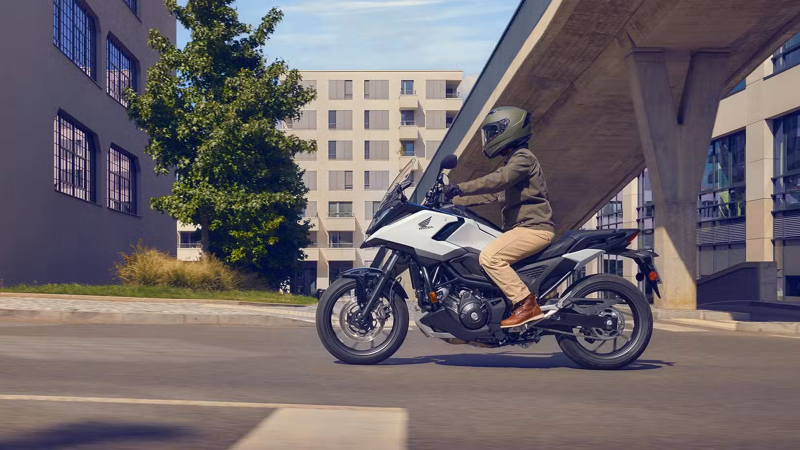 Side profile shot of the 2025 Honda NC750X DCT cruising on the highway