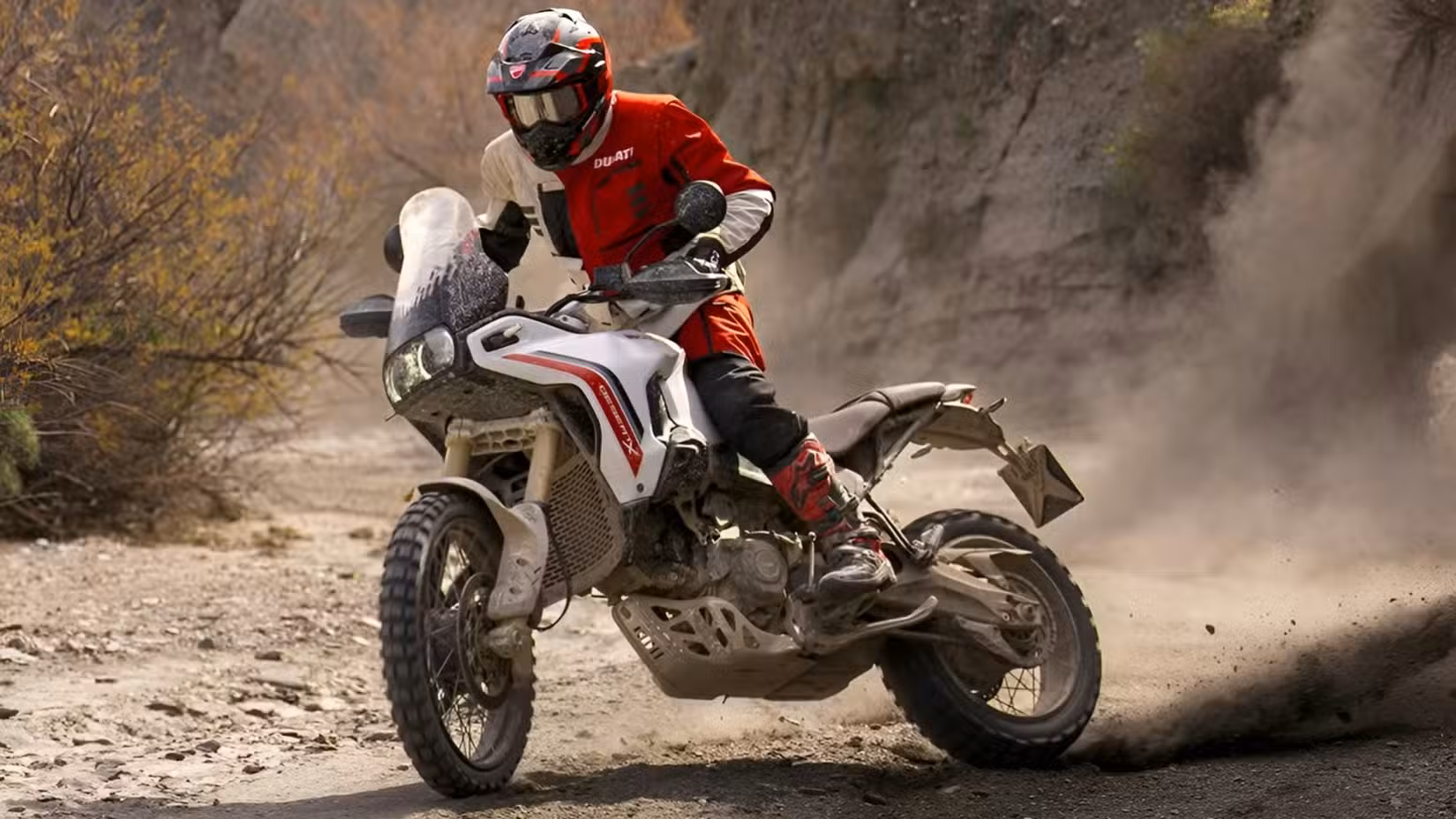 Action shot of a Ducati DesertX V2 doing a power slide off-road
