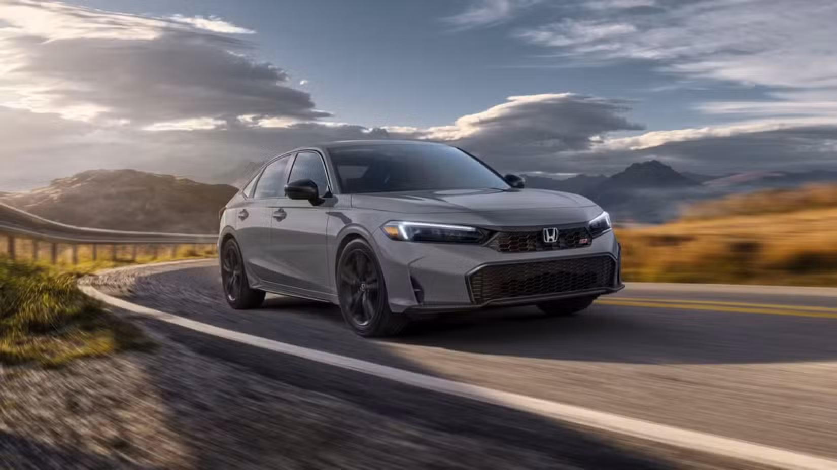 Front 3/4 action shot of 2026 Honda Civic Si driving on road
