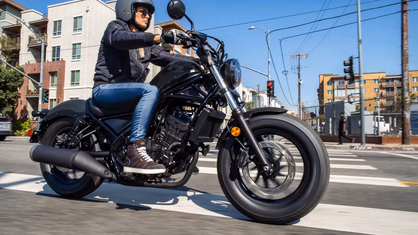 Action shot of a 2026 Honda Rebel 300 E-Clutch riding through town