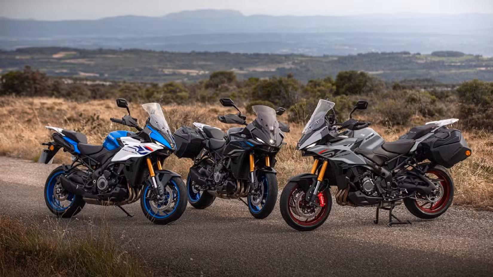 Static image of three Suzuki GSX-S1000GX+ bikes parked next to each other
