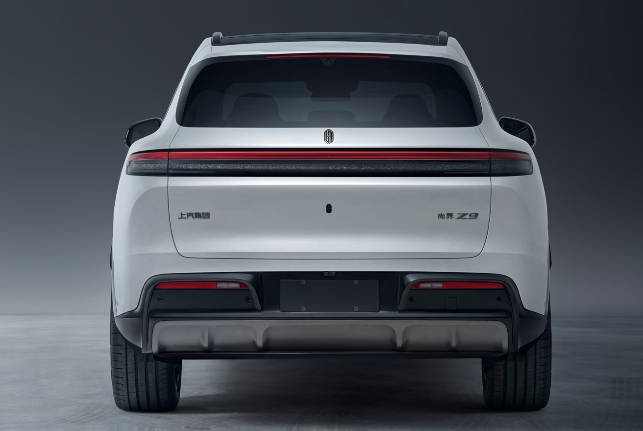 Rear view of a white Shangjie Z9 showing its full-width taillight, roof spoiler and tailgate badges.