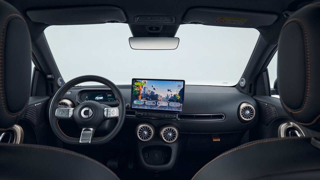 Smart #2 interior showing the steering wheel, digital instrument cluster, central touchscreen and circular air vents.