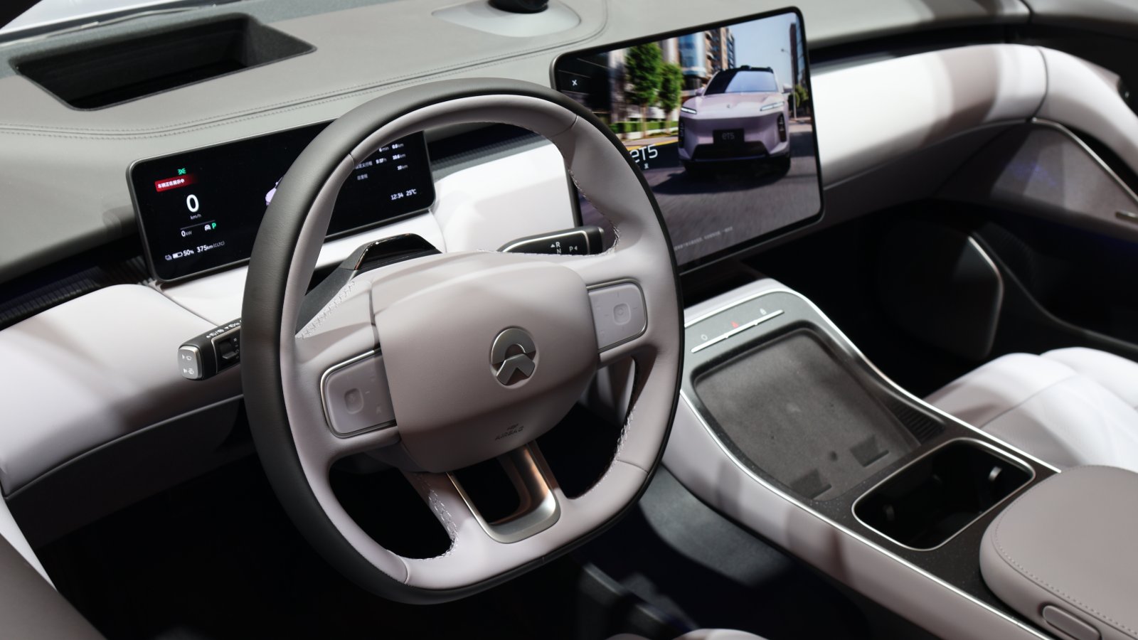 Nio steering wheel with integrated controls, a digital instrument cluster and a central touchscreen.