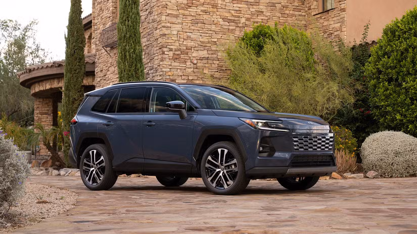 Front 3/4 view of a 2026 Toyota RAV4 Hybrid Limited parked in front of house