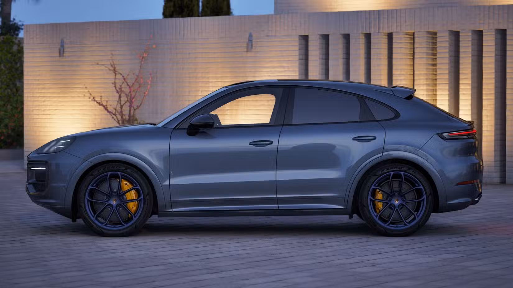 The side profile view of a grey 2027 Porsche Cayenne Coupe.