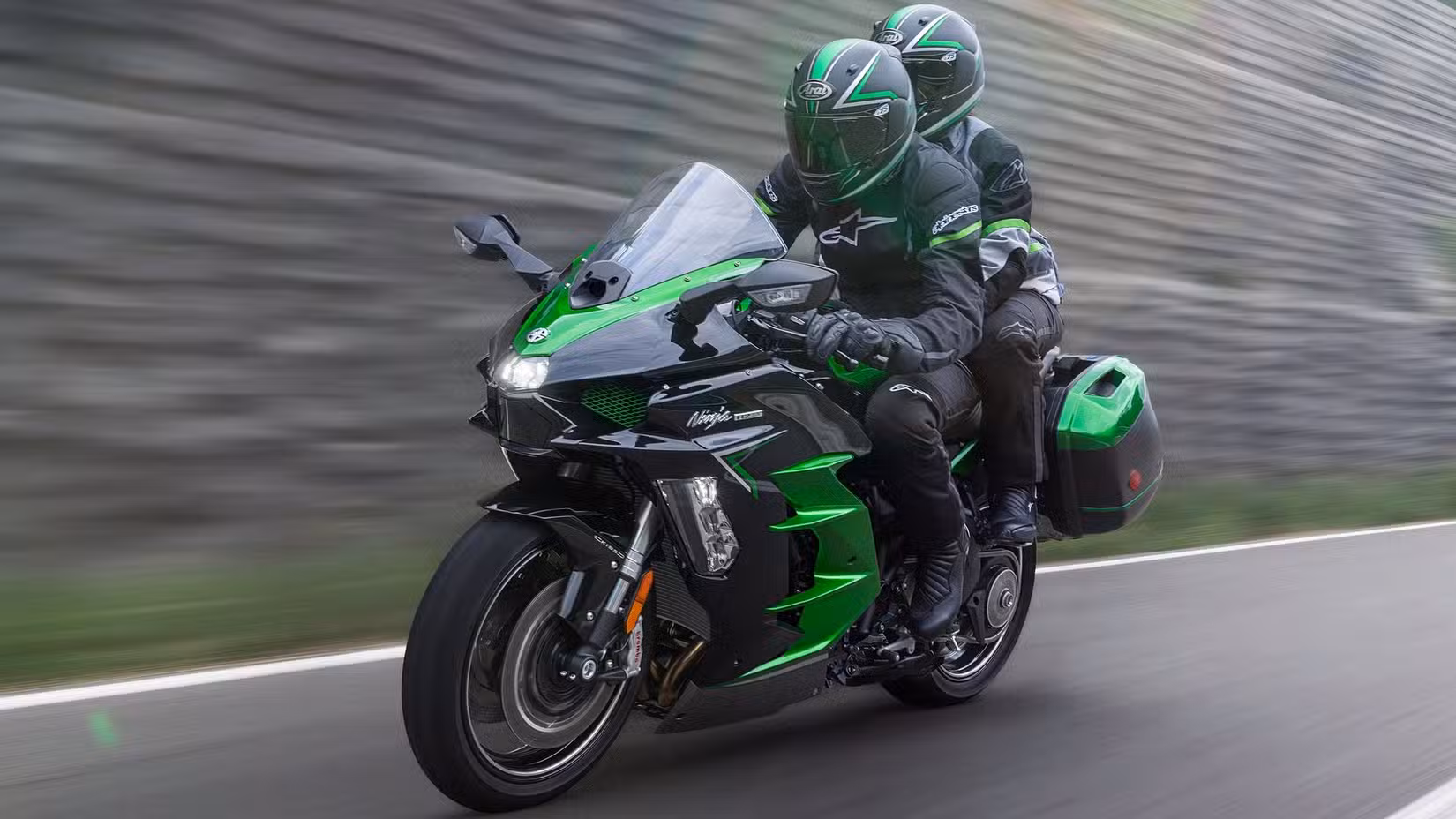2025 Kawasaki Ninja H2 SX touring bike accelerating wildly with a pillion onboard