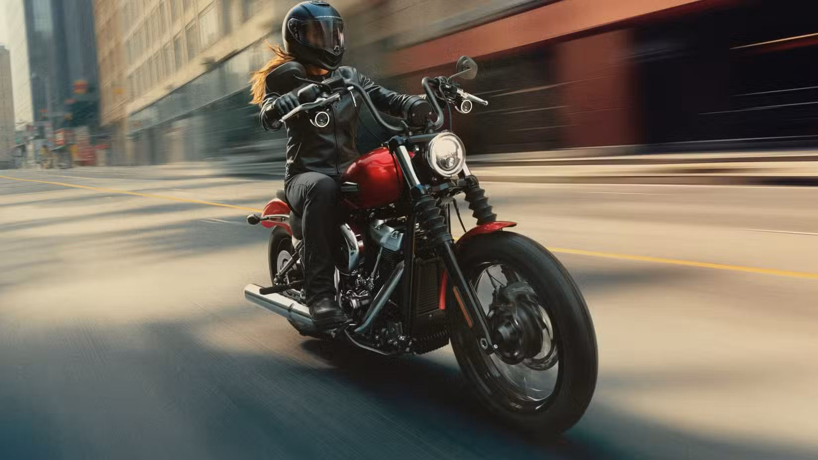 Red 2026 Harley-Davidson Street Bob cruising through town, front third quarter view