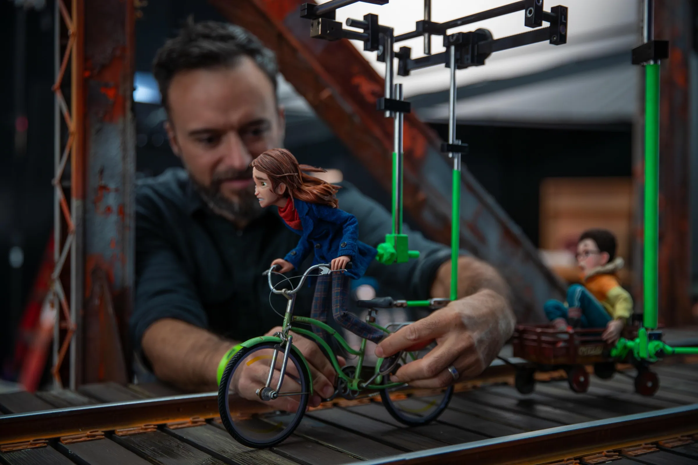 An animator poses a puppet riding a bike for the stop-motion film Wildwood.
