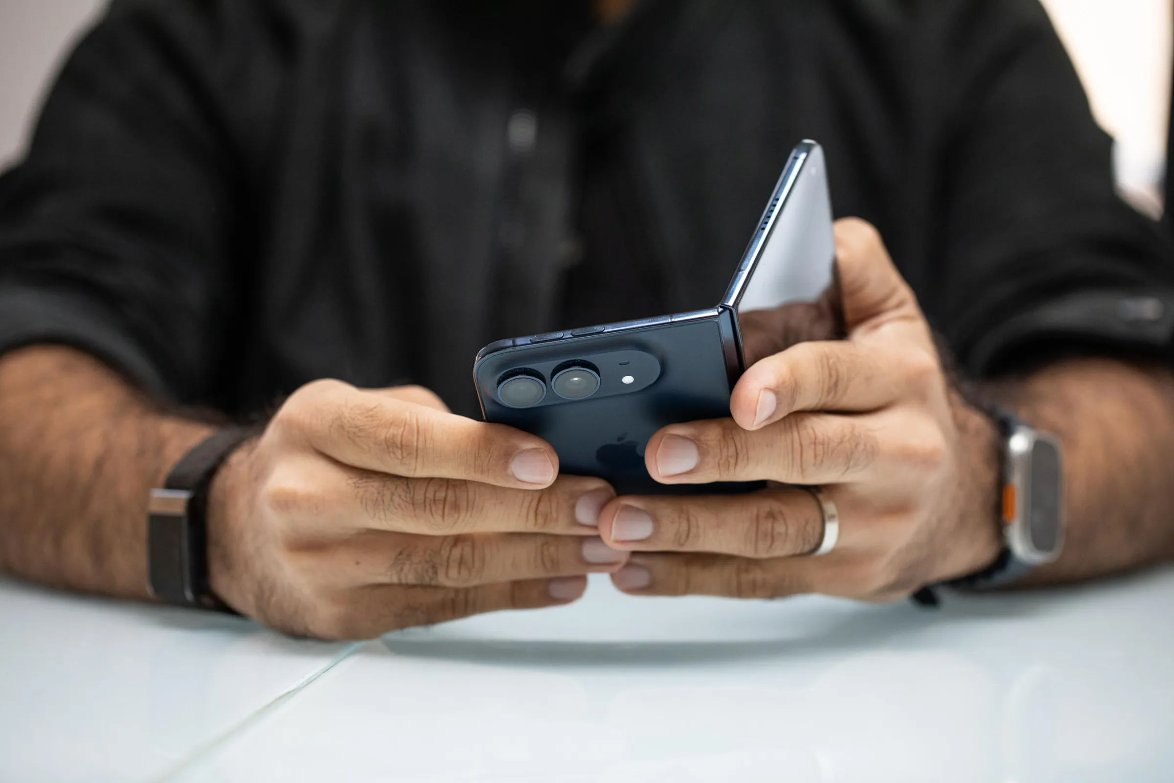 A person holding a blue iPhone Duo partway open, as if it were a book.