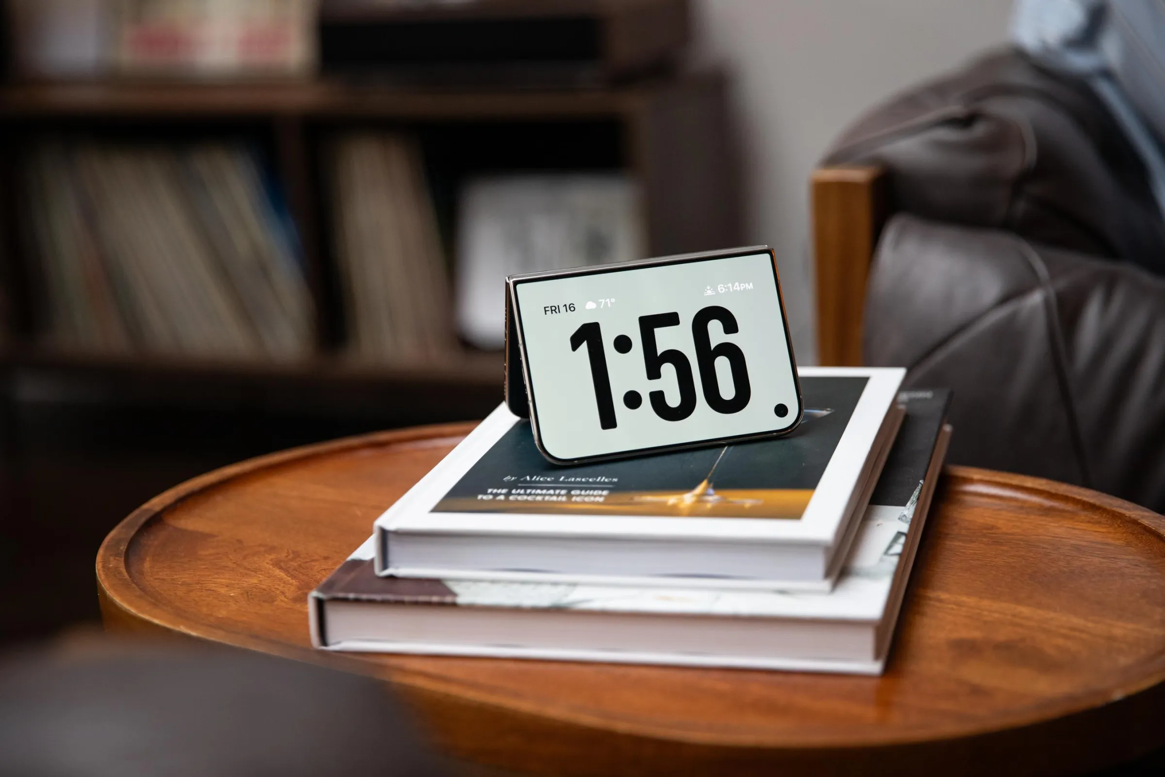An iPhone Duo tented on its side with the outer screen displaying the time.