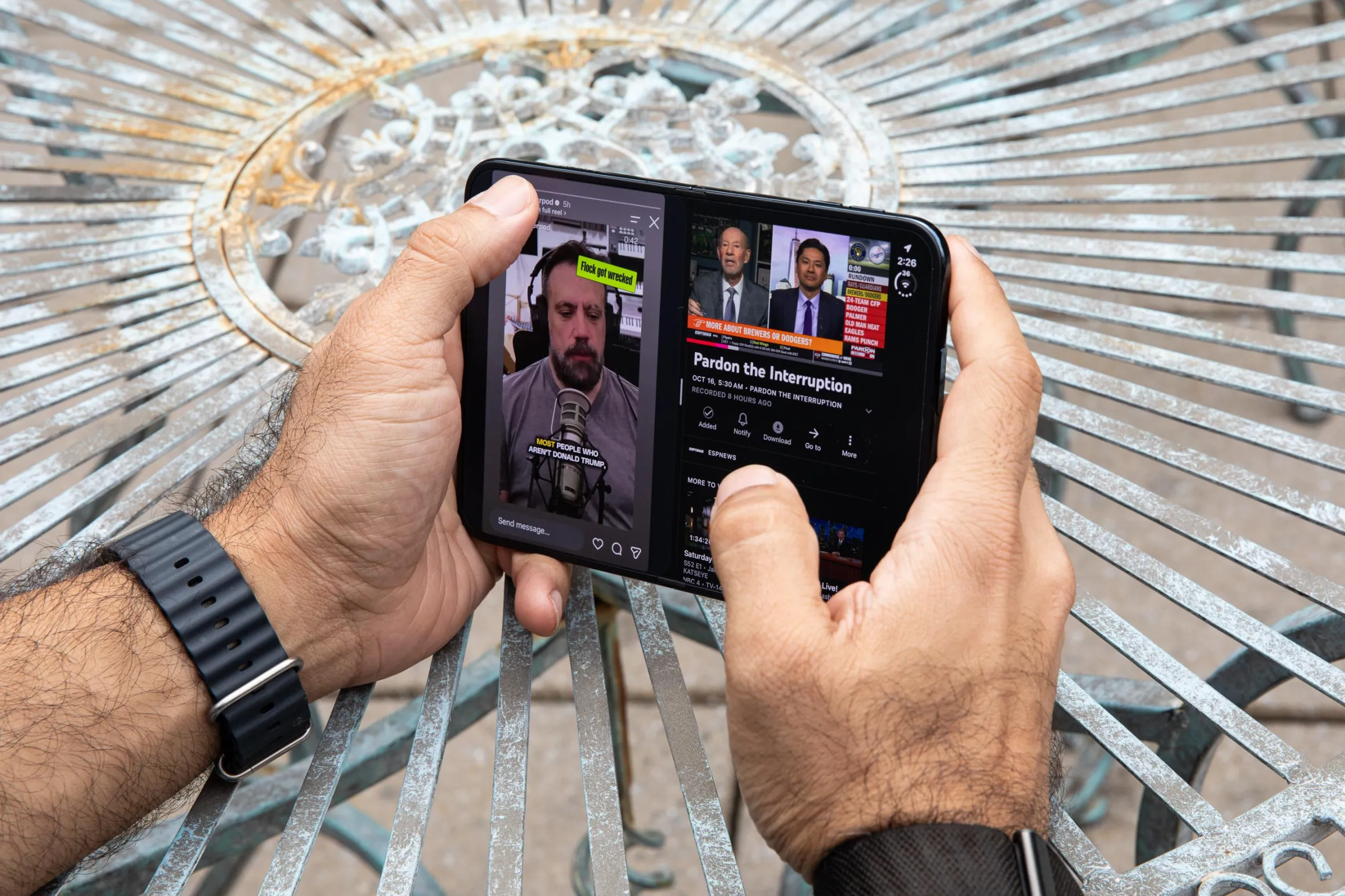 Hands holding an iPhone Duo opened to the inner screen in landscape orientation. Instagram is open on the left side, and a YouTube video is playing on the right.