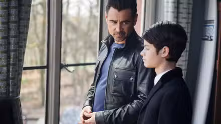a father and son stand by a window