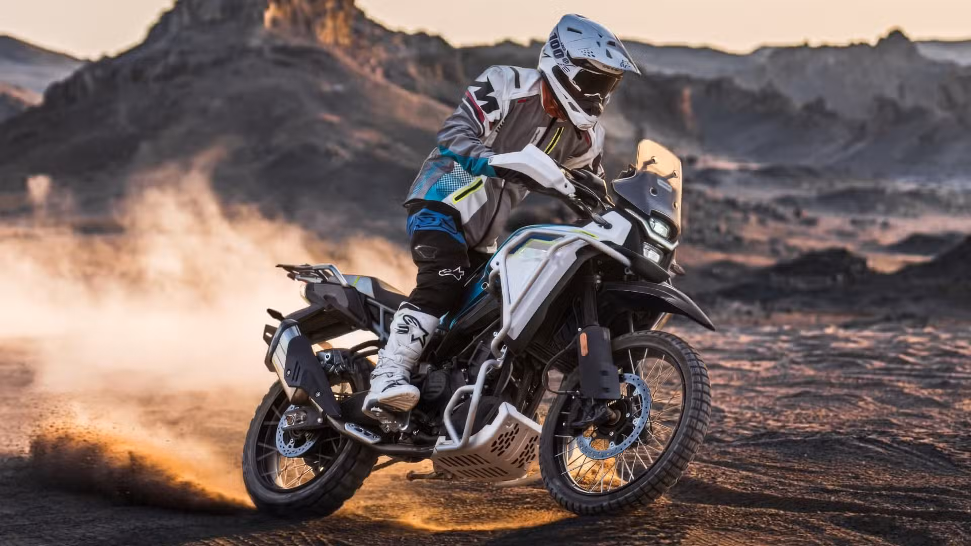 A rider power-sliding the 2026 CFMoto Ibex 450 on dirt front three quarter action shot