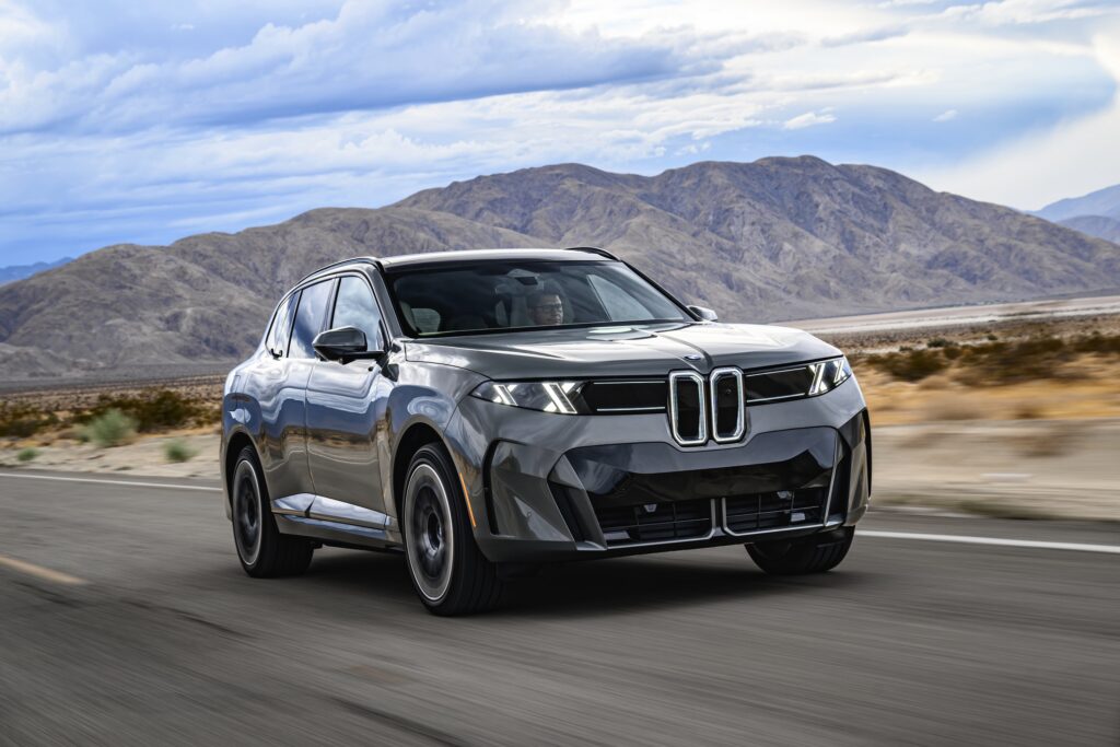 A BMW iX5 drives on the road.