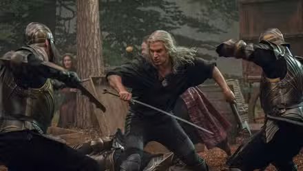 Geralt wields a sword and axe as soldiers attack him on each side in a fight scene from The Witcher season 3