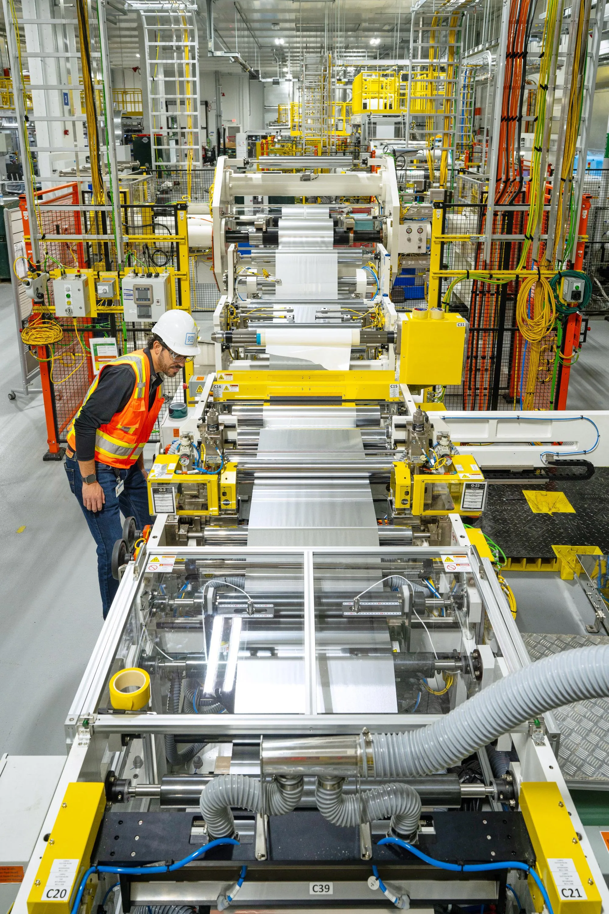 A GM engineer inspects equipment that gives battery developers a hands-on way to study and refine material handling before full-scale cell production.