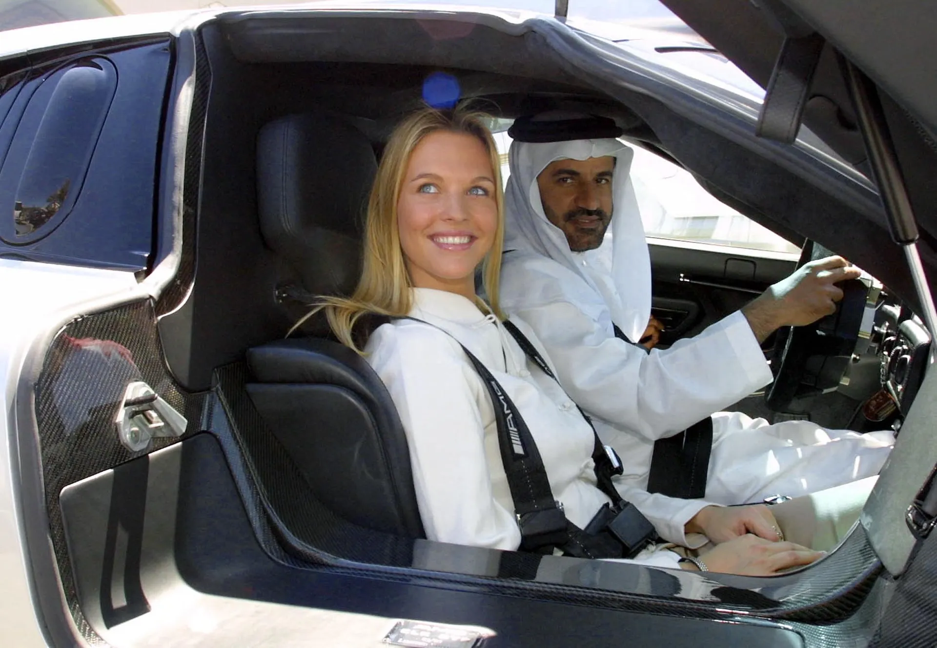 Wife of German soccer star Lothar Matthaeus, Maren Muller Wolfhart, checks out Emirati Middle East rally champion Mohammed Ben Sulayem's car, during a tour at Sulayem's house in Dubai 07 March 2001. Mattaus is in Dubai to participate in a friendly game with Emirati al-Nasr club against Iran's Istiklal club. AFP PHOTO/Rabih MOGHRABI (Photo by RABIH MOGHRABI / AFP)