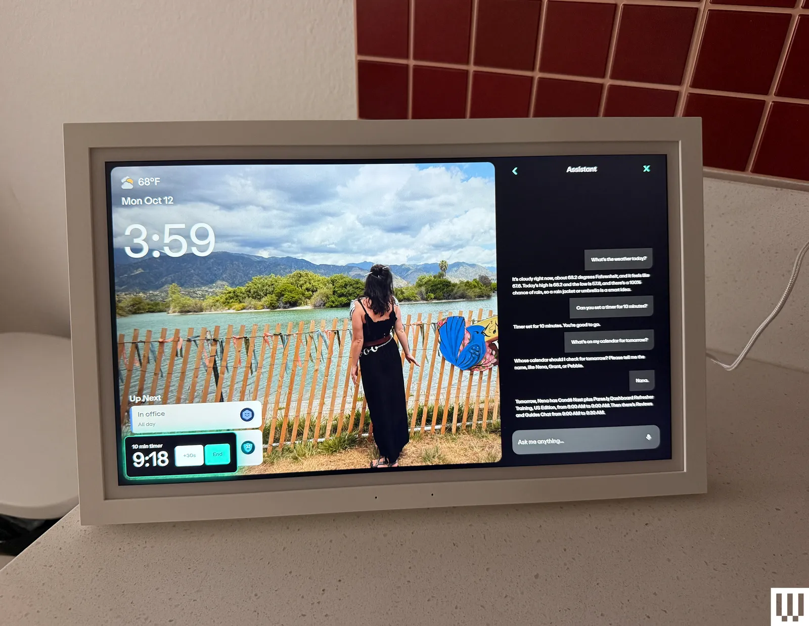 Small digital screen on top of a countertop showing a photo and a chat assistant