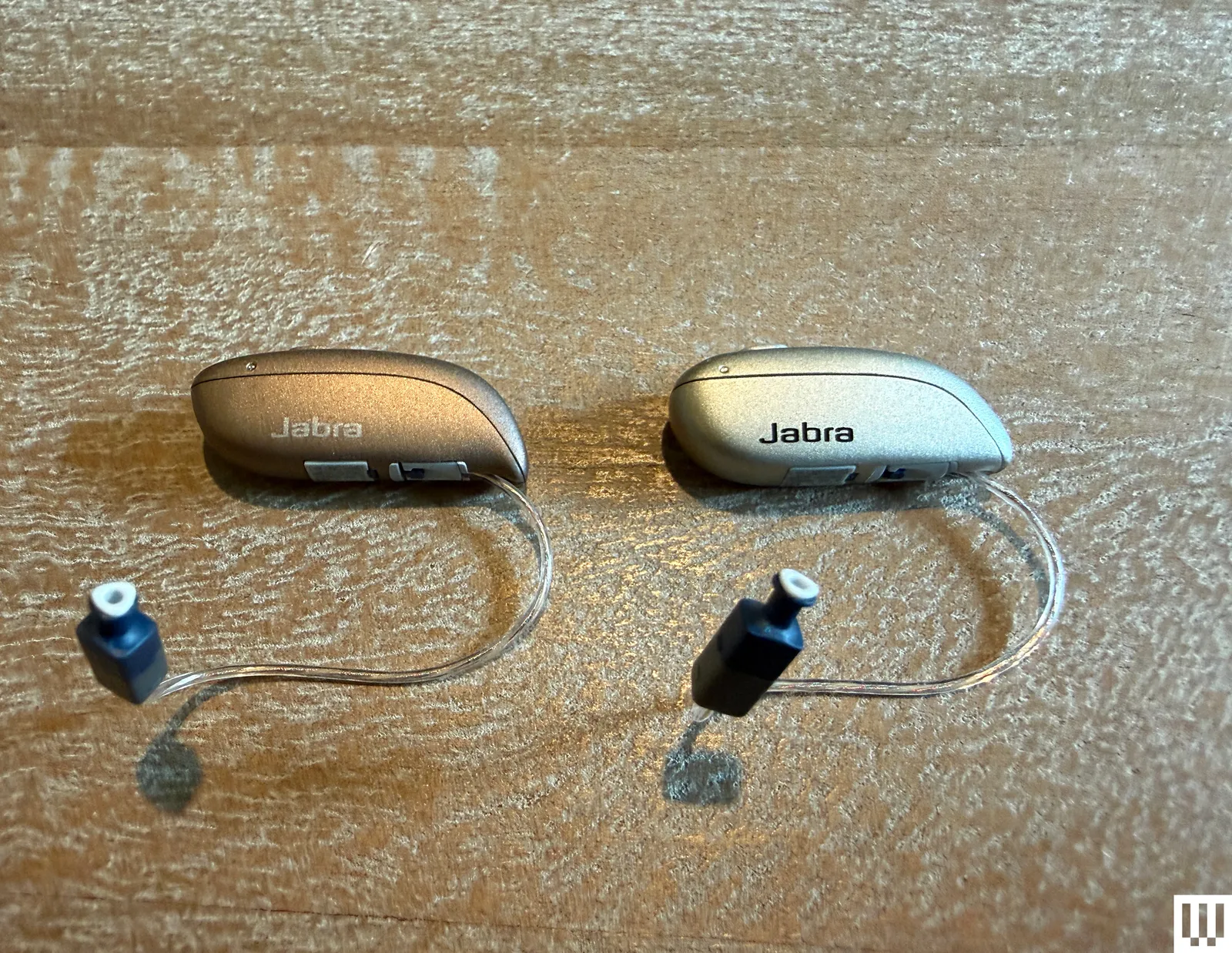 Pair of inear hearing aids on wooden surface