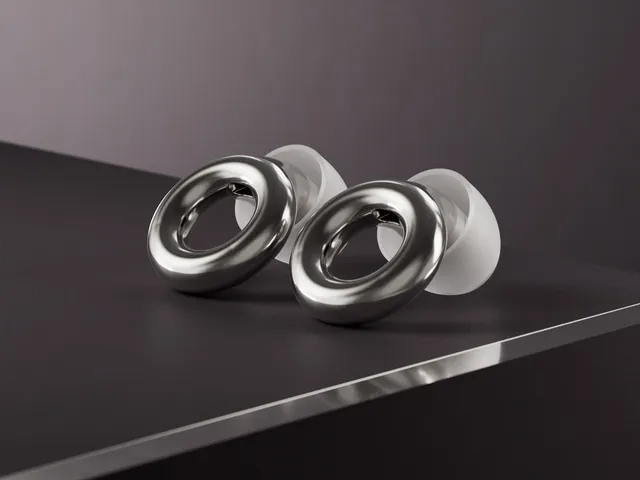 Loop Experience 2, dark grey earplugs with white cushions, sitting on a black surface