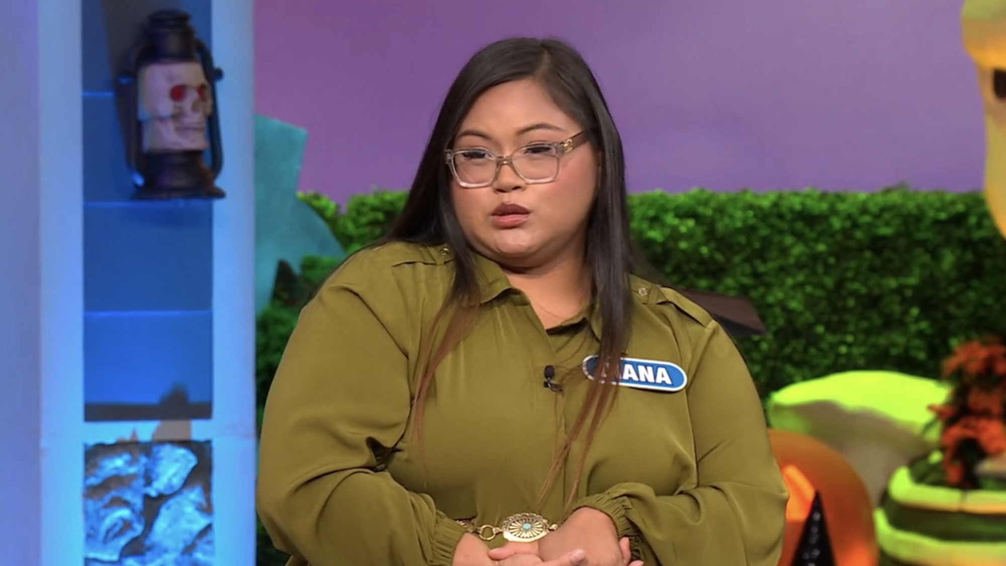 Diana in a green shirt looking confused on Wheel of Fortune's Halloween episode.