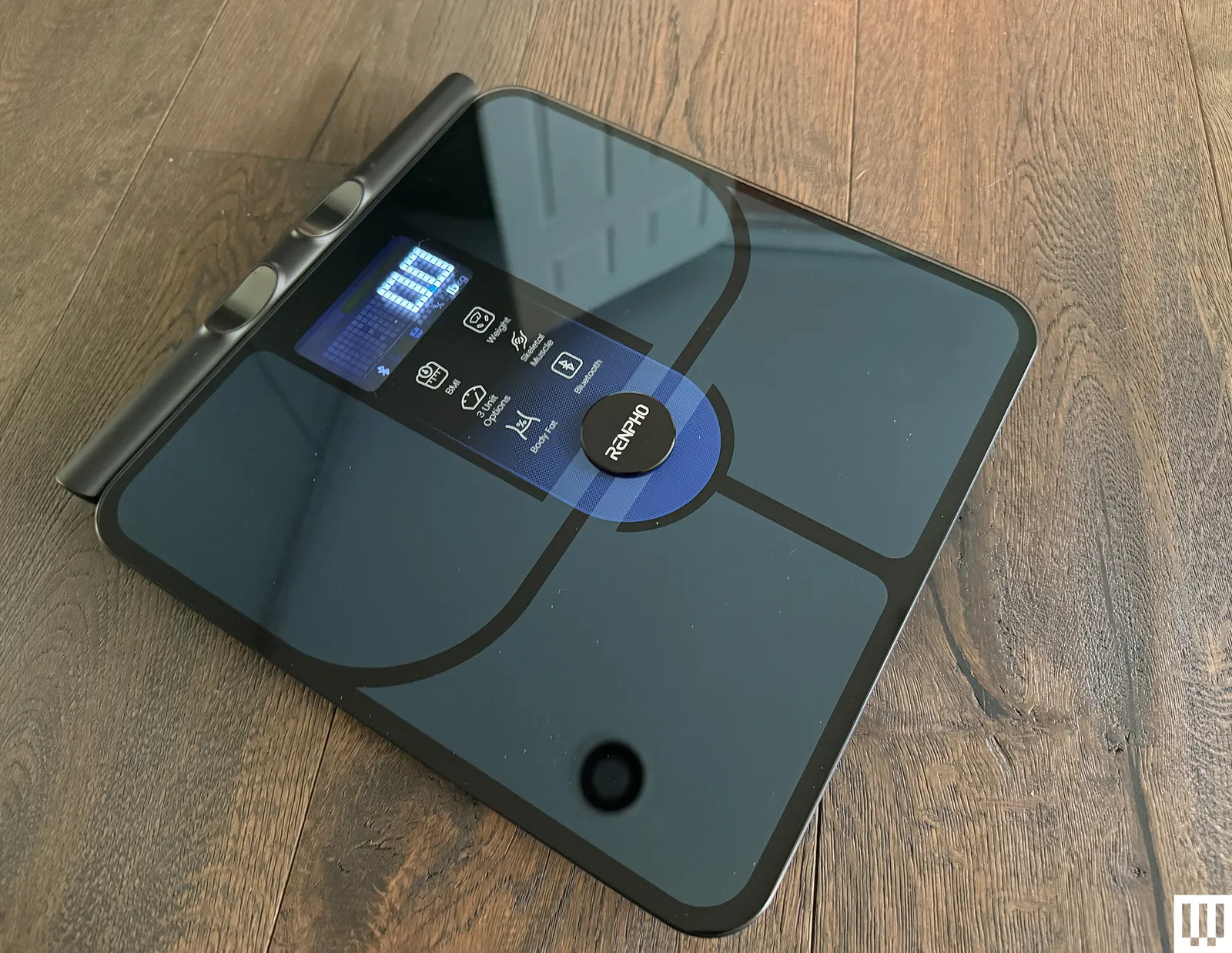 Slim black scale with digital screen on top of a wooden floor