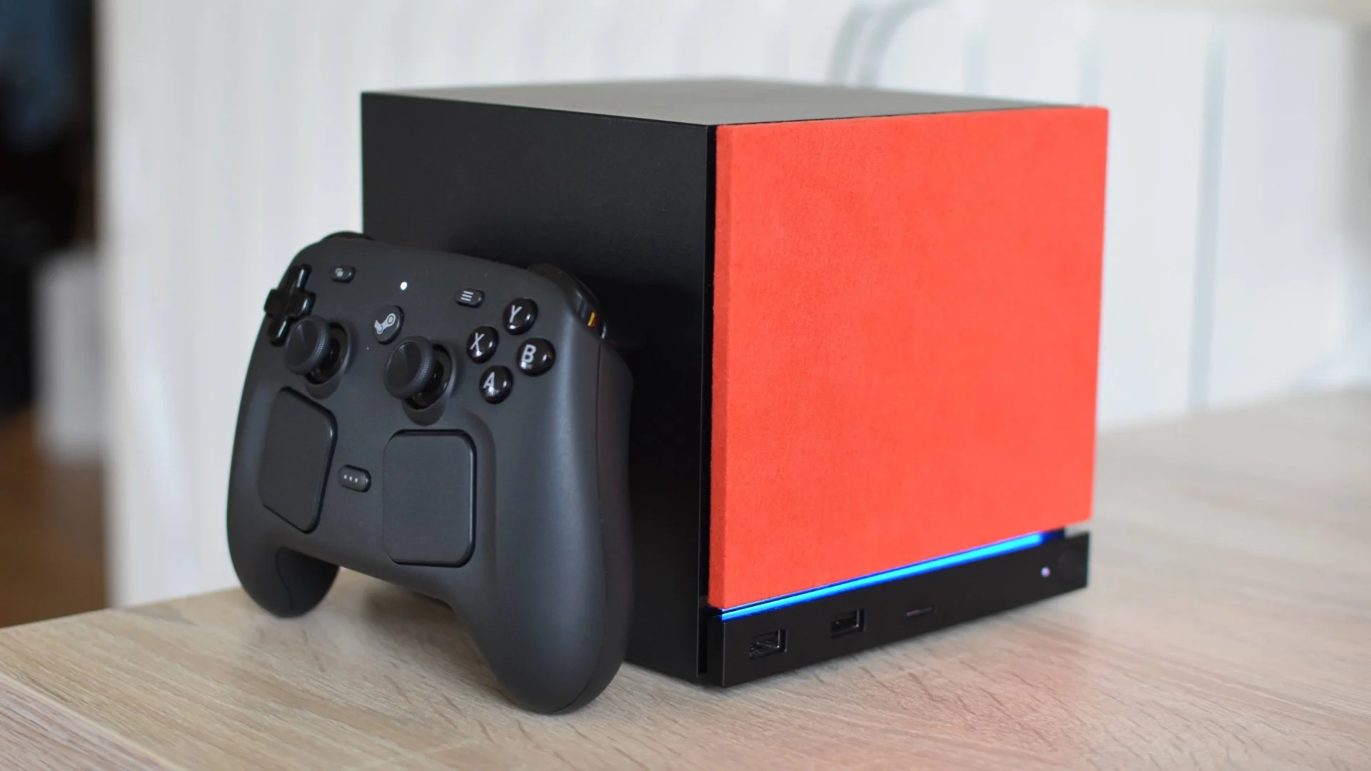 A Steam Machine with a Steam Controller propped up alongside it.