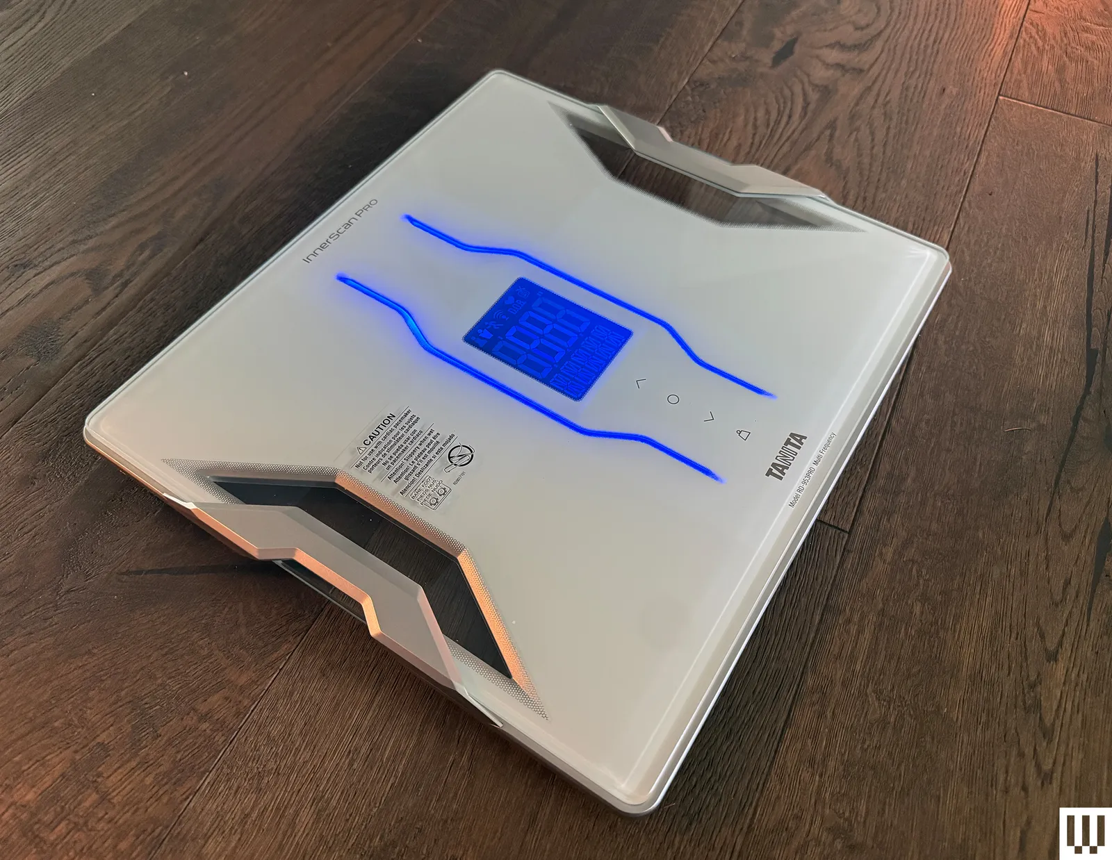 Slim white scale with digital screen on top of a wooden floor