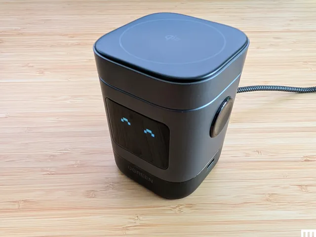 Front view of UGreen Uno 2-in-1 Magnetic Wireless Charger, a black rectangular device with the digital screen showing a smiling expression from pixels