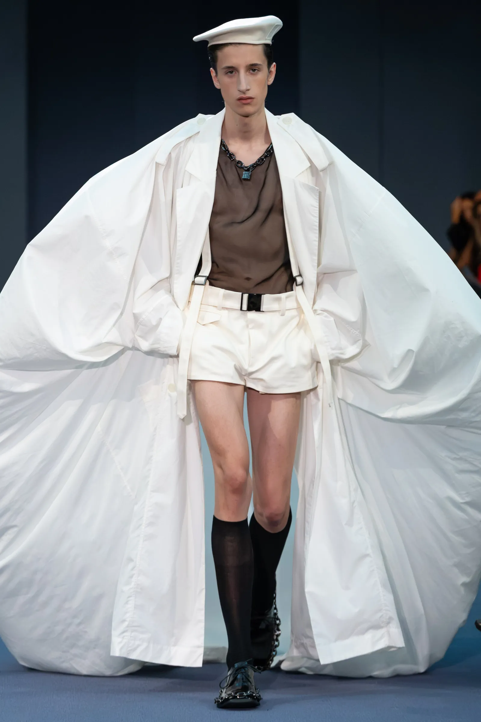 Image may contain Fashion Cape Clothing Shorts Long Sleeve Sleeve Dress Adult and Person