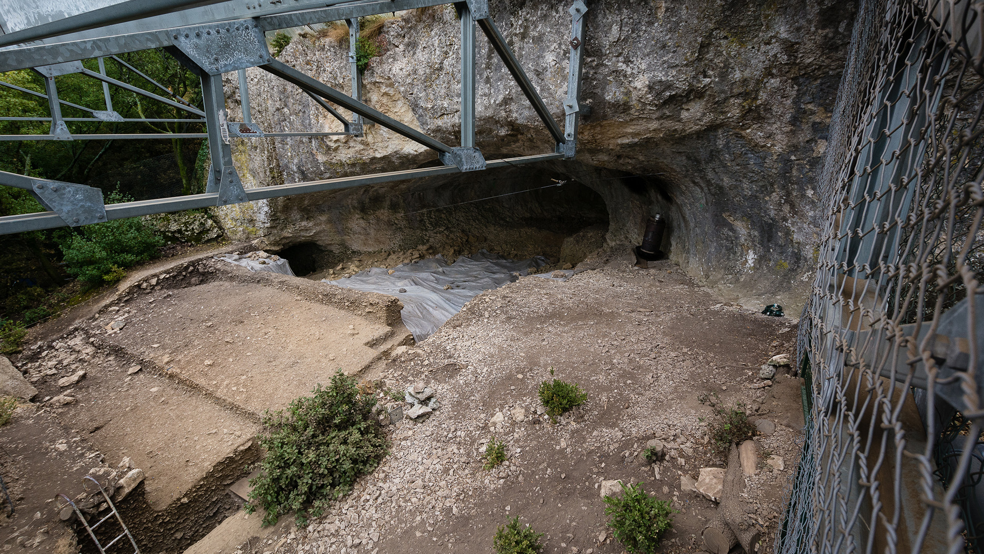 A look at a cave under a bridge.