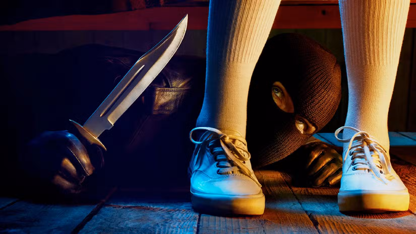 AHS 1984 poster shows a man with a knife under a bed and a woman's feet in front of him