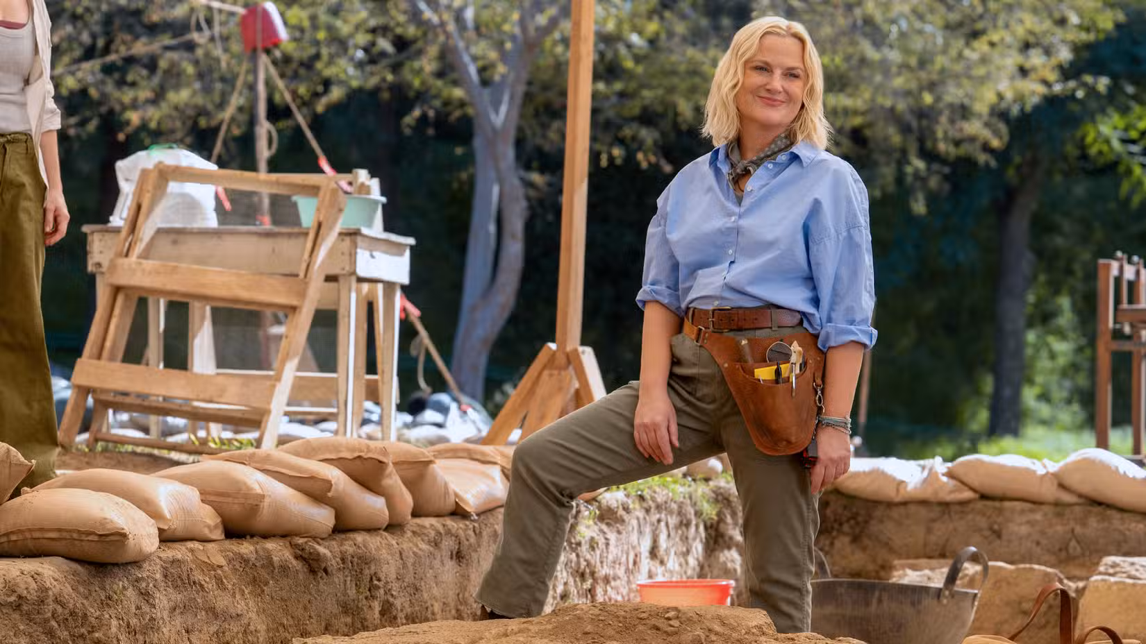 Amy Poehler standing at archeological site in Dig