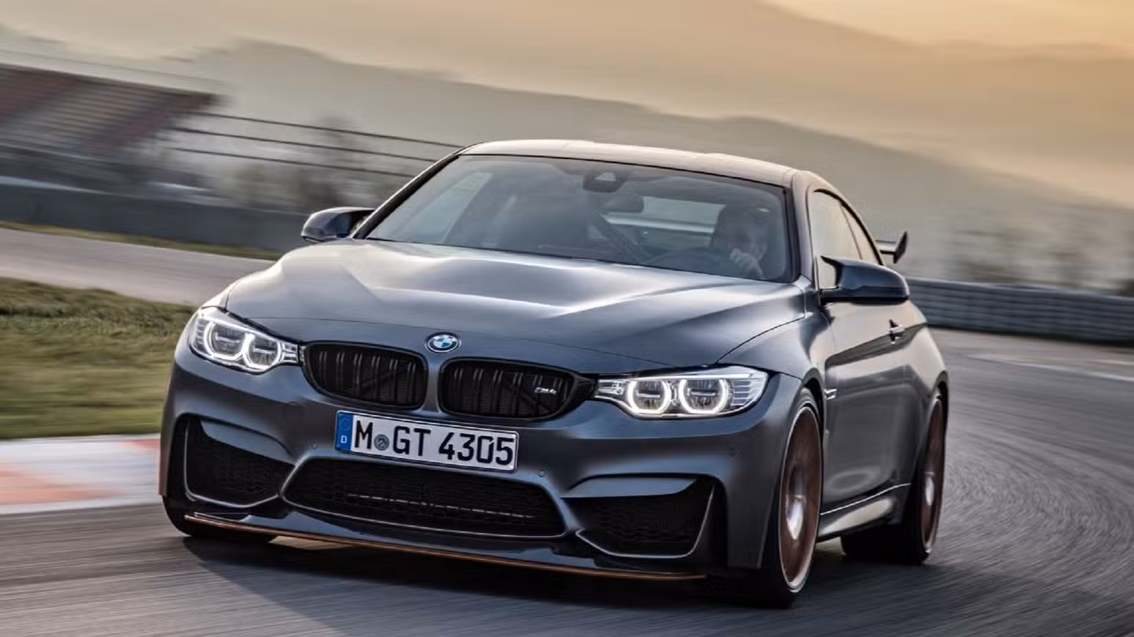 Front and side view of a BMW M4 GTS driving on the track