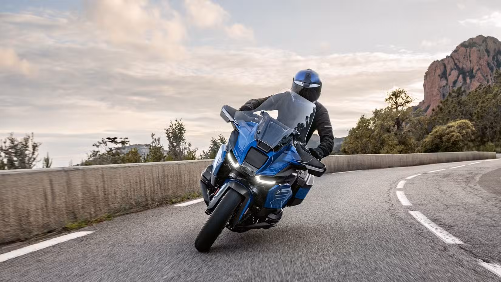 A 2026 BMW R 1300 RT cornering on a cliff road